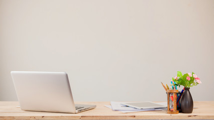 Comfortable working place. Close-up of comfortable working place in office with wooden table and laptop laying on it