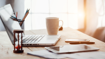 Comfortable working place. Close-up of comfortable working place in office with wooden table and laptop laying on it