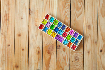 Colorful English letters in the wood boxes for decoration wording as a new year, Christmas on wooden background.