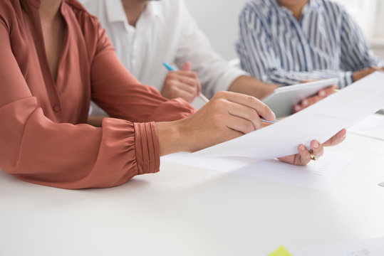 Cropped shot of businesswomen and man with paperwork and digital tablet boardroom table