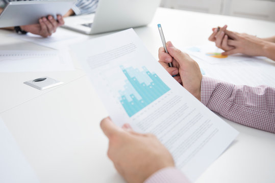 Cropped shot of businesswomen and men with paperwork and digital tablet boardroom table
