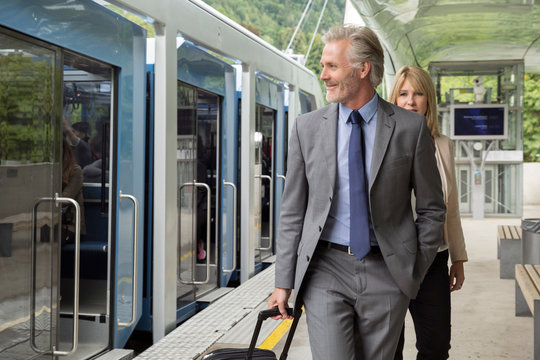 Businessman with suitcase on railway platform