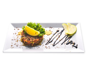 Salted salmon and fresh vegetables with balsamic sauce in a plate. Isolated on a white background.