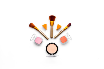 Decorative cosmetics pattern. Eyeshadows, rouge, brushes on white background top view