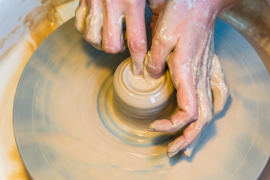 womens hands of a potter creating an earthen jar