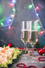 Crab salad tarts on wooden background. Christmas holiday buffet table served by snacks. Red baubles, fir-tree branches. Glass of champagne