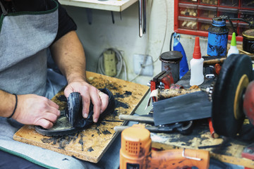 Shoemaker repairing a shoe sole in workshop