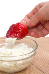 Hand with strawberries and cottage cheese