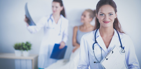 Woman doctor with folder standing at hospital