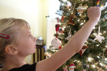 Young girl decorating christmas tree