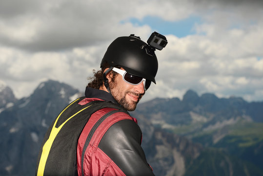 Portrait of base jumper wearing wingsuit with action camera on helmet, Dolomite mountains, Canazei, Trentino Alto Adige, Italy, Europe