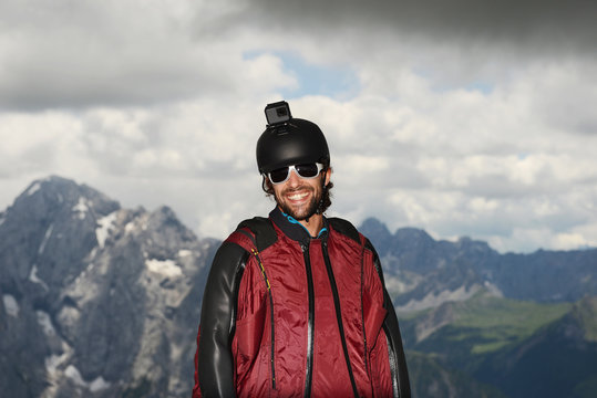 Portrait of base jumper wearing wingsuit with action camera on helmet, Dolomite mountains, Canazei, Trentino Alto Adige, Italy, Europe