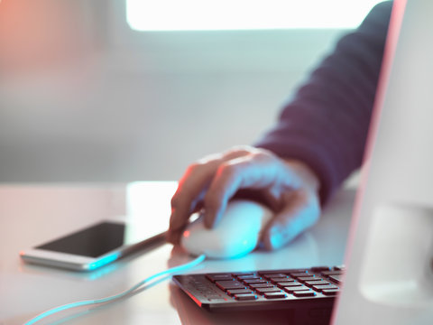 Computer hacker at laptop computer with mobile phone