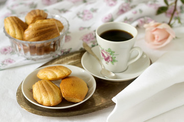Madeleine, served with coffee. Traditional French pastries. Romantic breakfast. Style ryustik, selective focus.