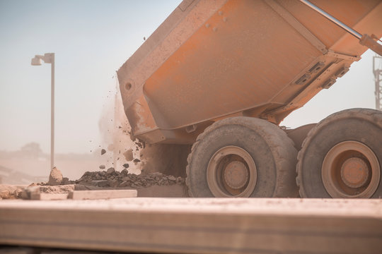 Dump truck in quarry, tipping load of stones