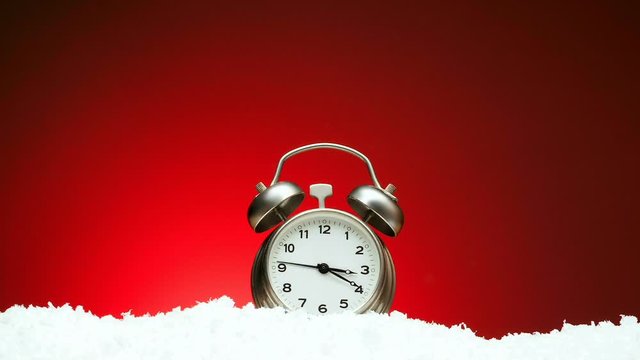 Countdown from twelve to twelve. Video countdown to midnight holiday christmas xmas new year Greeting footage for new year alarm clock on snow on red background with place for congratulatory text 1080