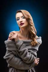 Naklejka premium Beautiful blond girl wearing a gray sweater with an elegant hairstyle.