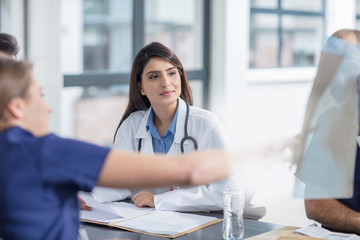 Group of doctors sitting at table, having discussion