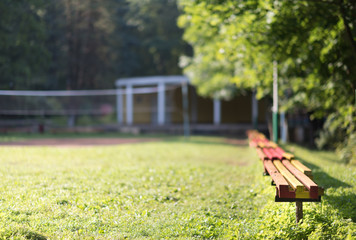 Yellow and red old wooden seats at the sand volleyball court(selective focus)