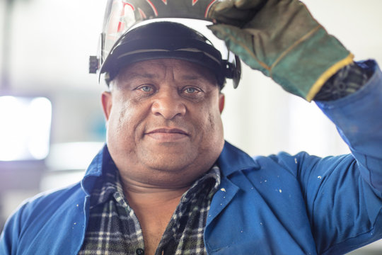 Portrait Of Mature Male Car Mechanic In Welding Mask At Repair Garage