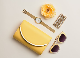 Fashion. Minimal Style. Woman Accessories Set. Flat lay. Trendy fashion Clutch, Glamour Summer Sunglasses. Flower. Luxury Spring lady. Yellow Pastel Color