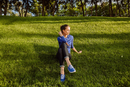 Woman sitting on grass looking away, Odessa, Odeska Oblast, Ukraine, Europe