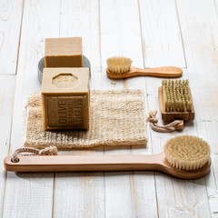 Fototapeta na wymiar simple traditional solid soaps, exfoliating loofah and wooden body brushes