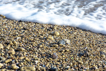  foamy surf on a stony bank