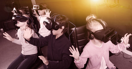 Enthusiastic children in virtual reality glasses in quest room