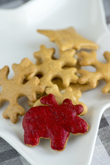 Traditional tasty Czech gingerbreads, Christmas snowflakes and reindeer on white star shaped plate on grey chequered tablecloth