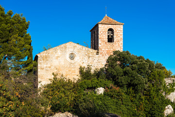 Fototapeta na wymiar View of the Romanesque church of Santa Maria de Siurana, in Siurana, Tarragona, Spain. Copy space for text. Isolated on blue background.