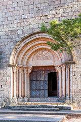 Fototapeta na wymiar View of the main entrance to the church of Santa Maria de Siurana, in Siurana, Tarragona, Spain. Copy space for text. Vertical.