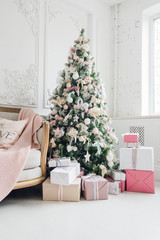 New Year's holiday or celebration, the mood, Stylish Christmas minimalistic interior, Presents and wrapped gifts under the Christmas tree. large white living room with a vintage sofa