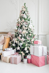 beautiful modern design of the room in delicate light colors decorated with Christmas tree and decorative elements