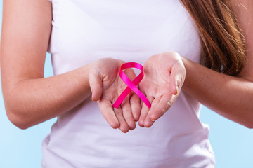 Woman with breast cancer awareness ribbon on hands