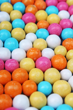Shiny sugar coated round chocolate balls as background. Candy bonbons multicolored texture. Round candies sweets pattern concept. Food photo studio photography. Candy background Choco dragee.
