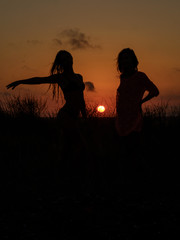 Fototapeta na wymiar Silhouettes of women at sunset 2