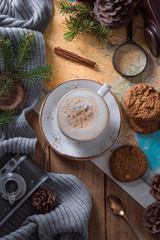  cup of cappuccino on a wooden table, map and magnifier.