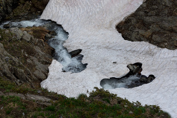 The melting glacier and snow of the mountain peaks in the European Alps during spring