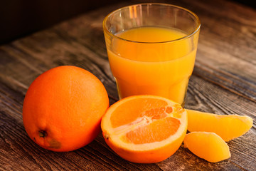 Oranges and orange juice on a wooden background