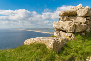 View from the South West Coast Path  towards Fortuneswell and Chesil Beach, Isle of Portland, Jurassic Coast, Dorset, UK - with clouds over Weymouth in the background