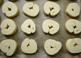 Raw sweet puff pastry bun ears on  parchment paper on baking sheet