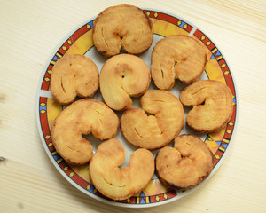 Sweet puff pastry bun ears on a colorful plate on wooden table