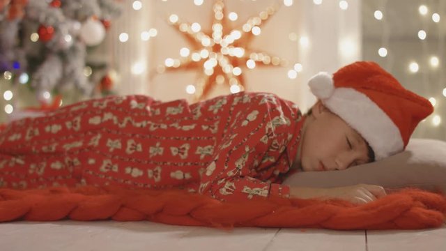 Santa Claus takes the gift over while the boy is sleeping