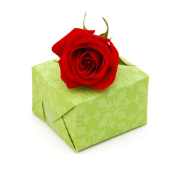 Green gift box  and red rose flower isolated on white