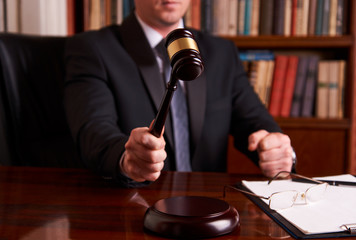 Male lawyer or judge hand's striking the gavel