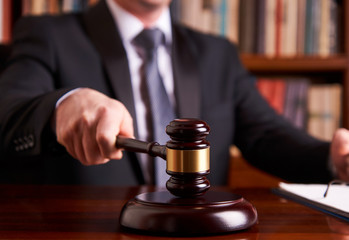 Male judge in a courtroom striking the gavel 