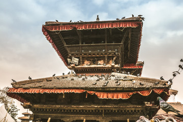 old sacred building hindu temple with beautiful roof wooden and many pigeons. kathmandu. nepal