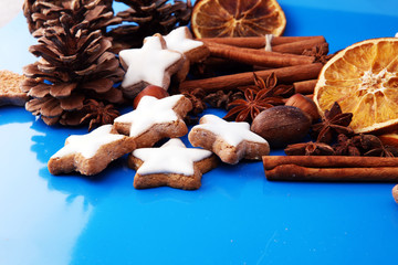 Christmas border. Xmas Gingerbread cookies, spices and decorations on blue background.
