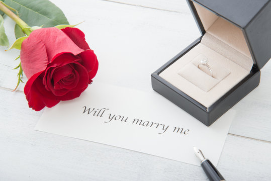propose message with diamond ring and rose